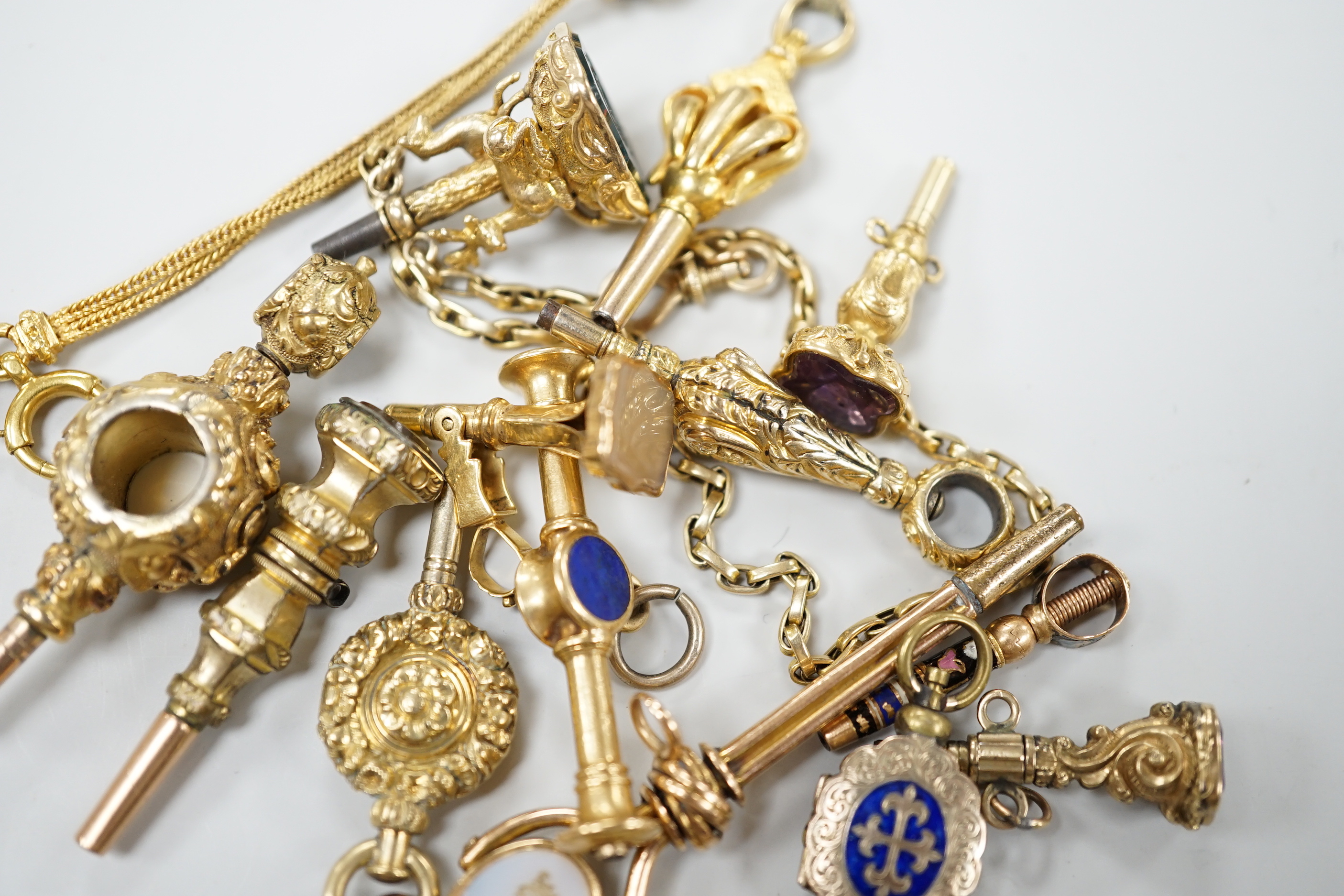 A small collection of fifteen assorted mainly 19th century yellow metal or gold plated watch keys including, one rose cut diamond set, one enamelled locket, six gem stone set, one enamelled, one surmounted with deer and